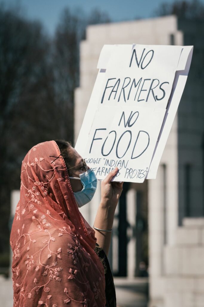 A woman supports the Indian farmers' protest with a sign that says 'No Farmers No Food'